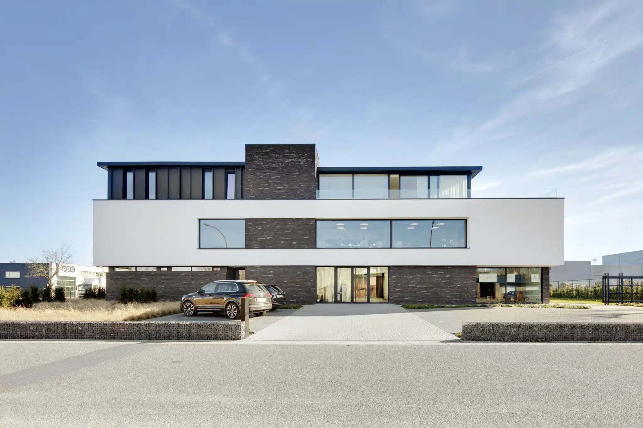 Nieuwbouw kantoorgebouw MVH Security in Sint-Niklaas, ontworpen door ONA Architecten met gevelsteen, pleisterwerk en donkere