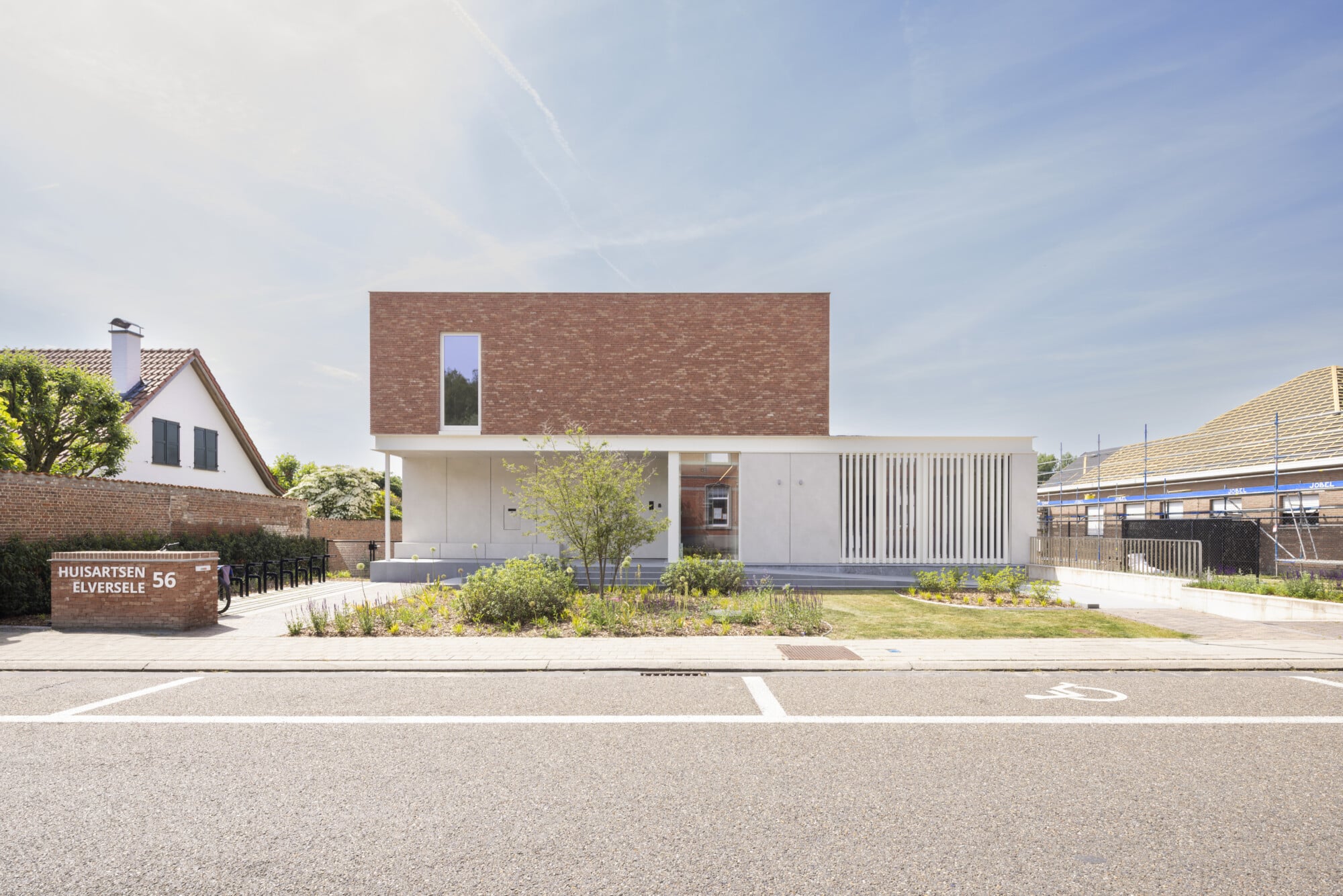 Artsenpraktijk Elversele, moderne geneeskundige praktijk met rode bakstenen bovenverdieping en witte gevelbekleding, ONA Arch