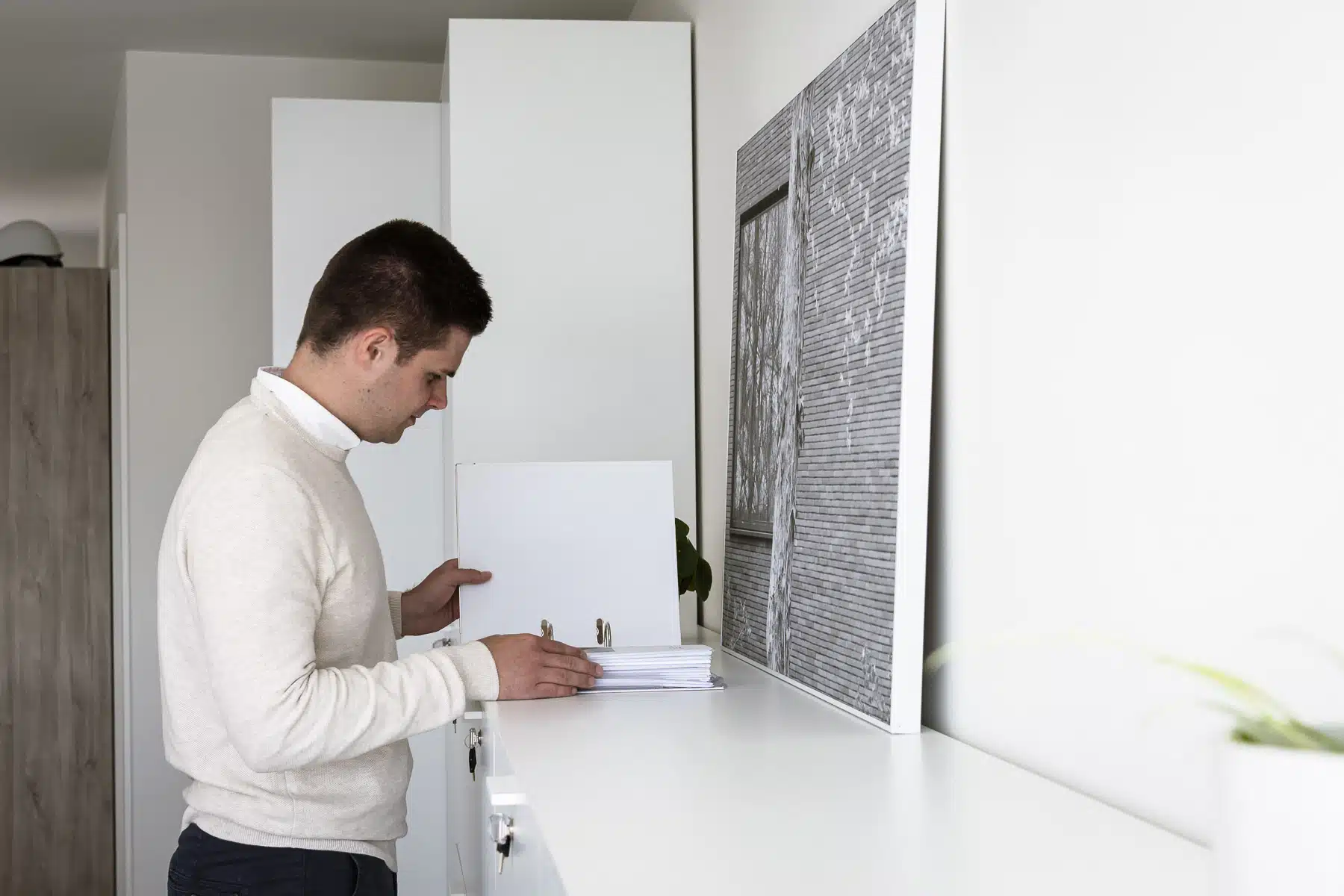 Architect van ONA Architecten bekijkt een uitvoeringsdossier in het kantoor in Beveren tijdens de voorbereiding van een bouwp
